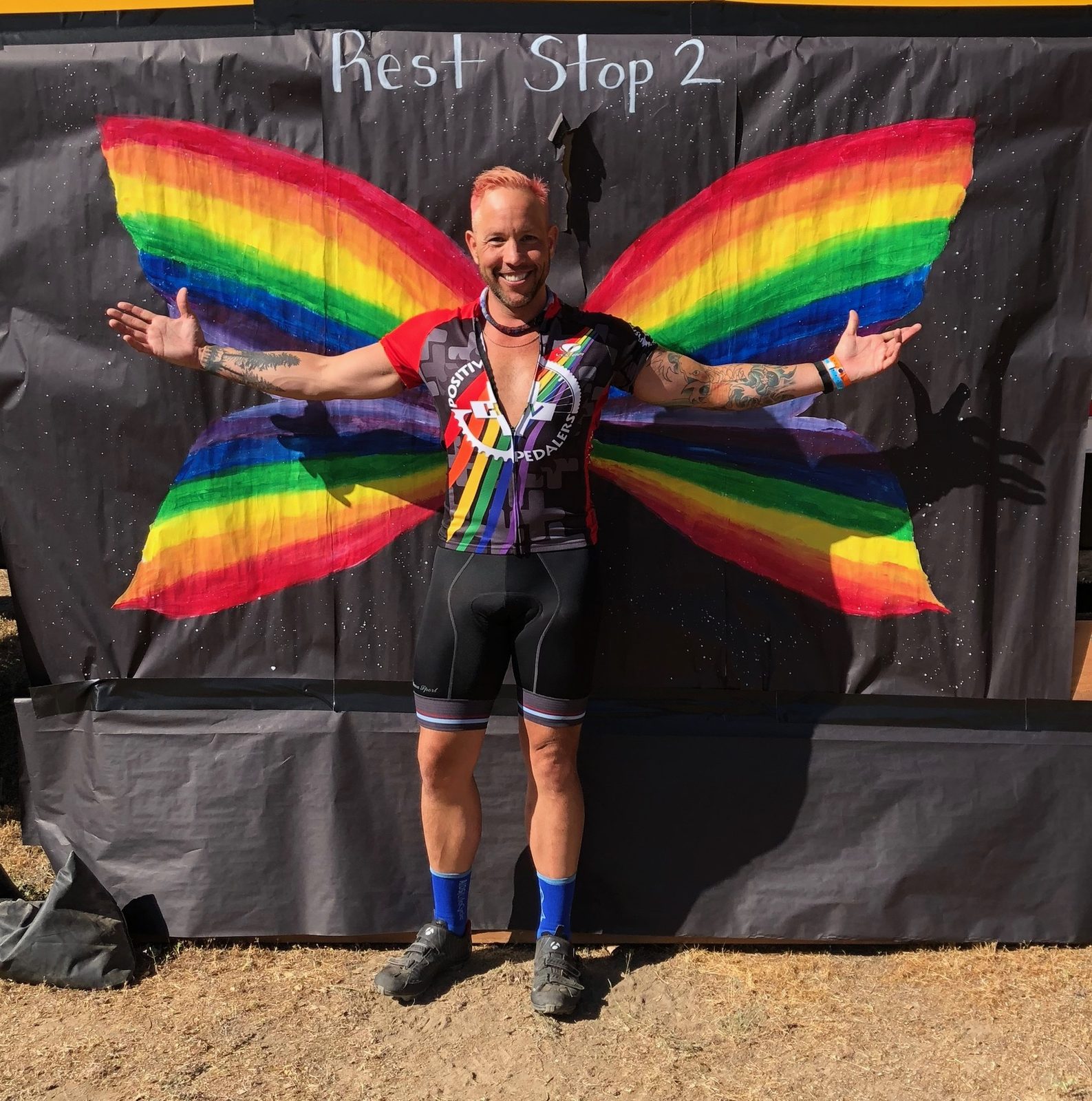 Garrett McClure with rainbow butterfly wings at an AIDS/LifeCycle rest stop