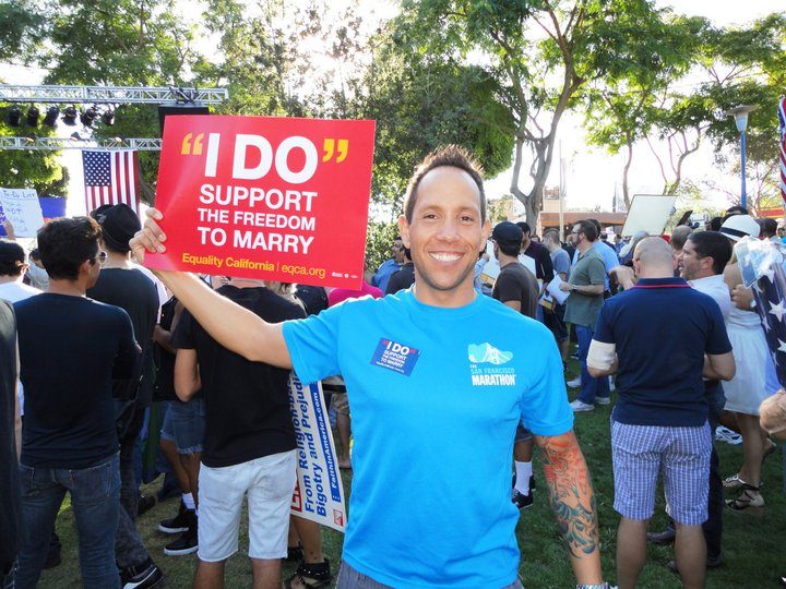 Garrett McClure holding a sign reading I support the freedom to marry